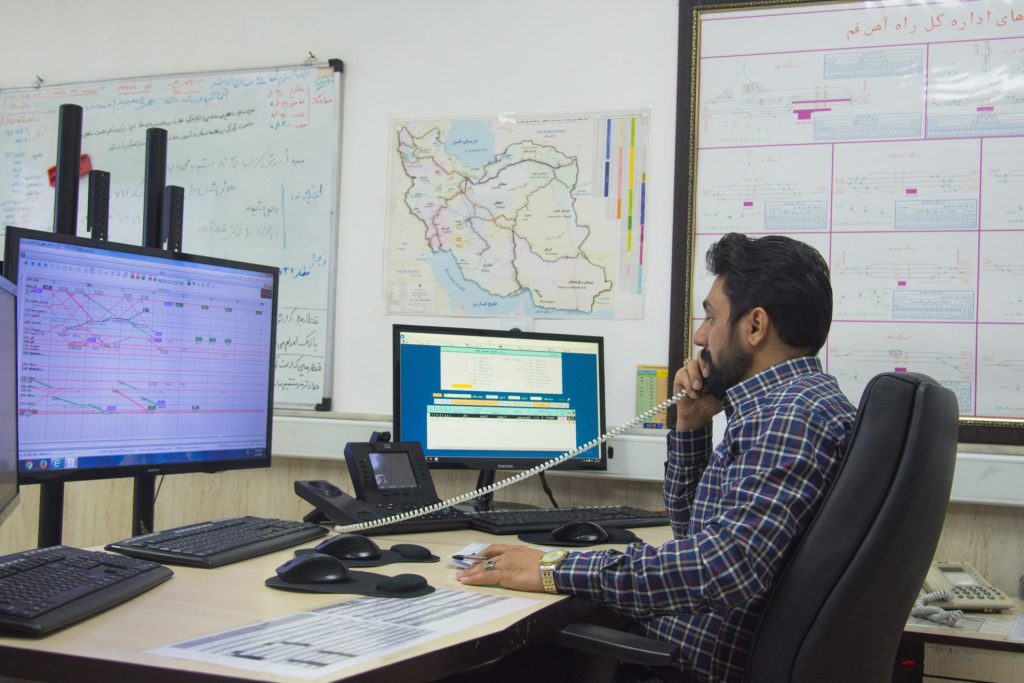 a man sitting at a desk talking on a phone